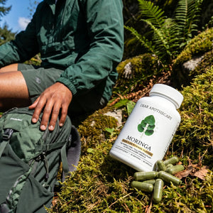 Person taking Moringa during an outdoor hiking break
