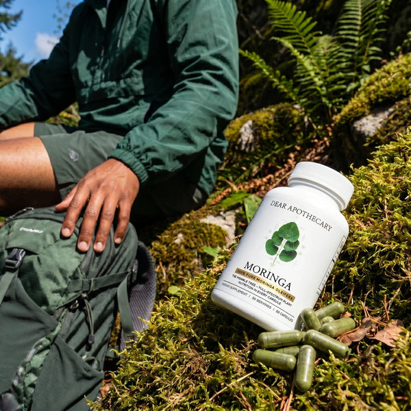Person taking Moringa during an outdoor hiking break
