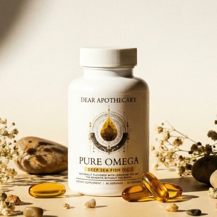 Pure Omega bottle on sand with softgels and dried flowers